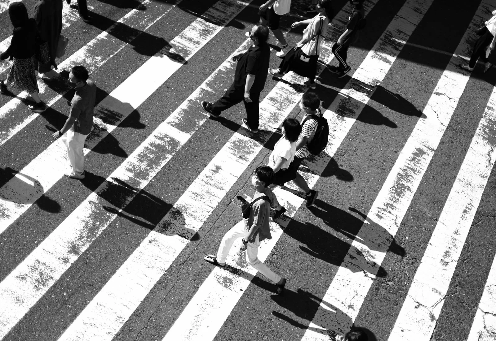 横断歩道を渡る人々の黒い影