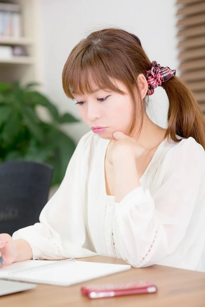 気持ちを書き出してノートを見つめる女性