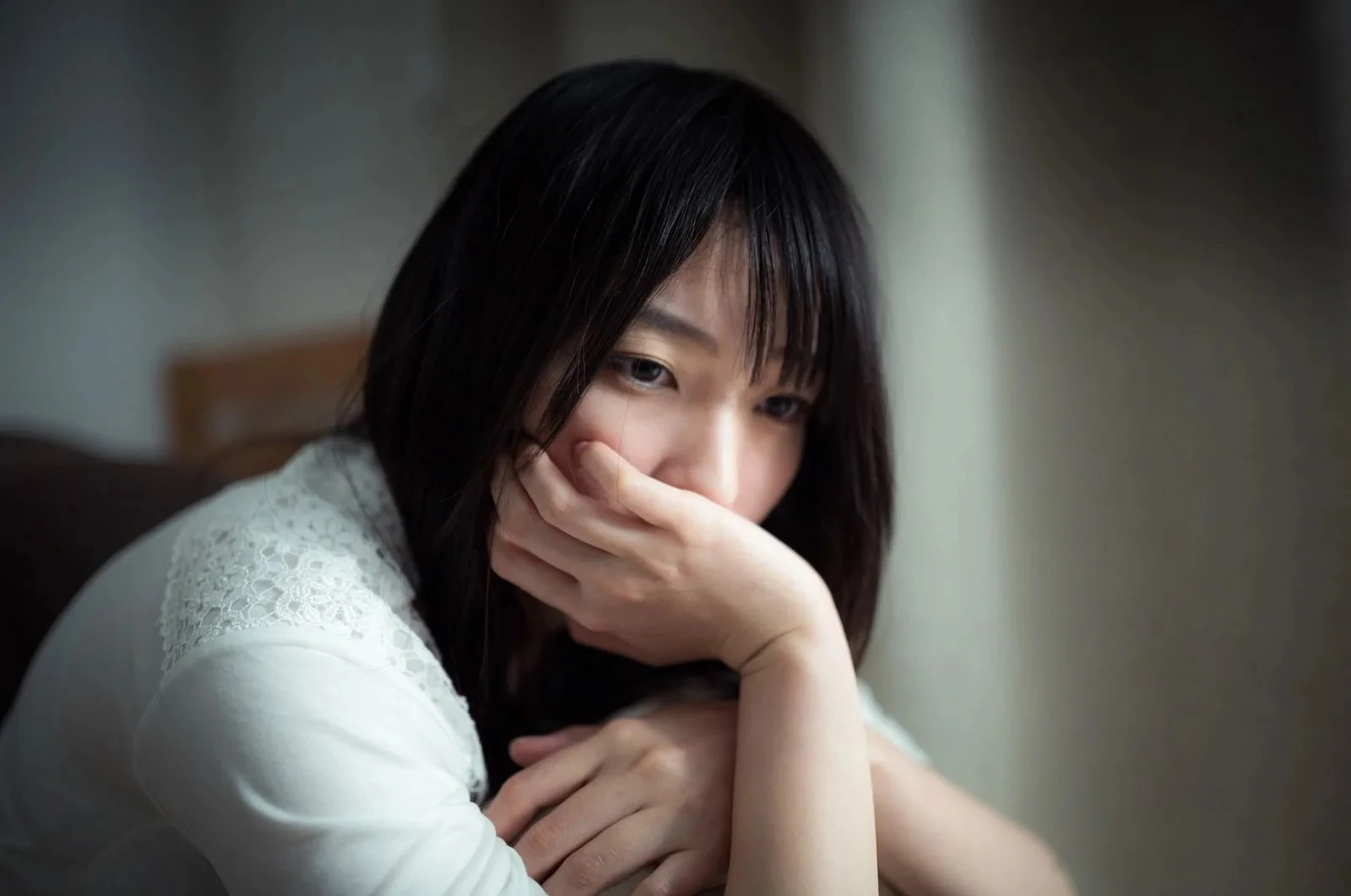 頬杖をついて俯く女性