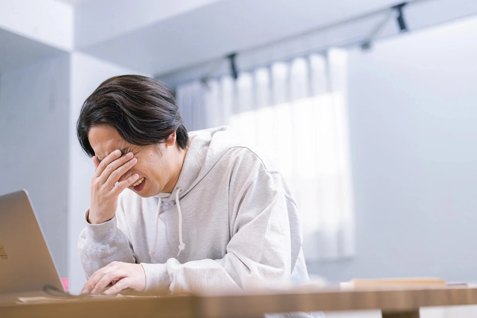 孤独感から顔を覆う男性