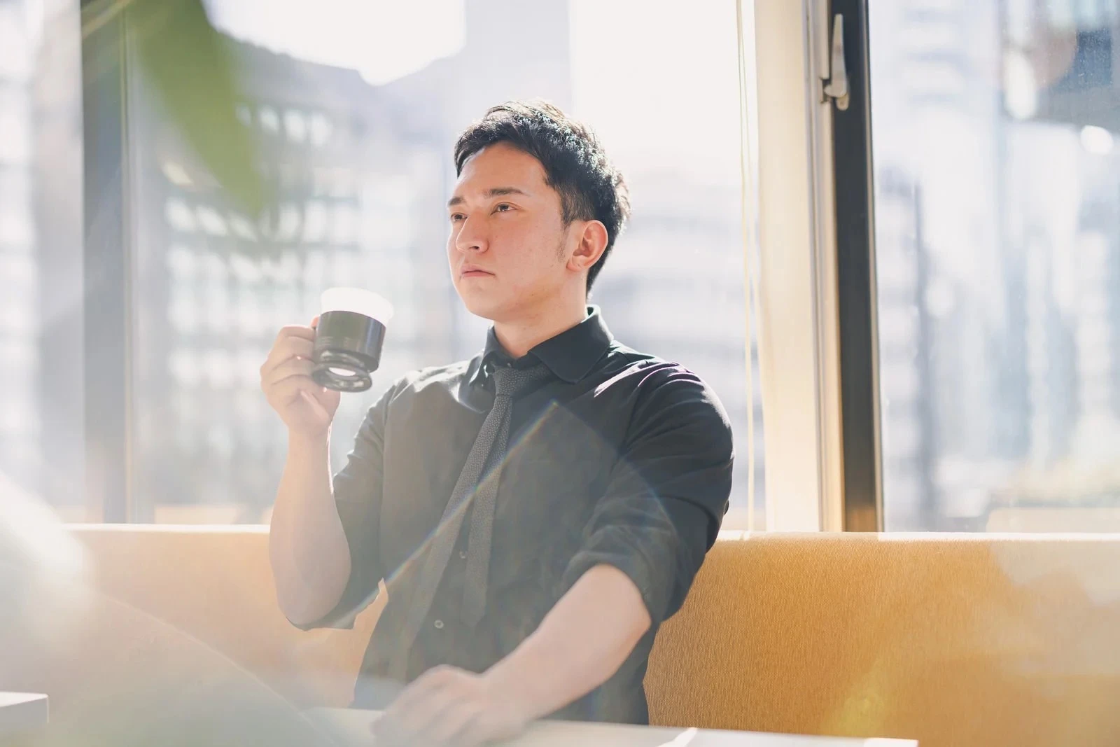 誰かと待ち合わせてコーヒを飲む男性