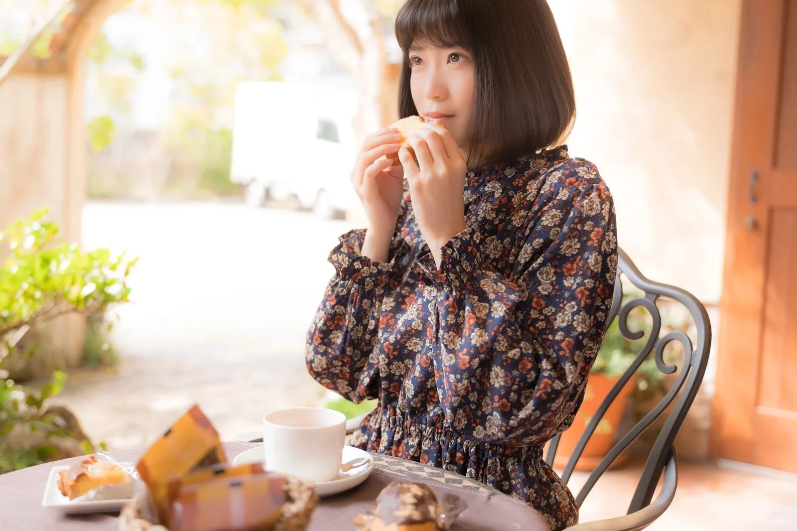 パンを食べながら誰かを待つ女性