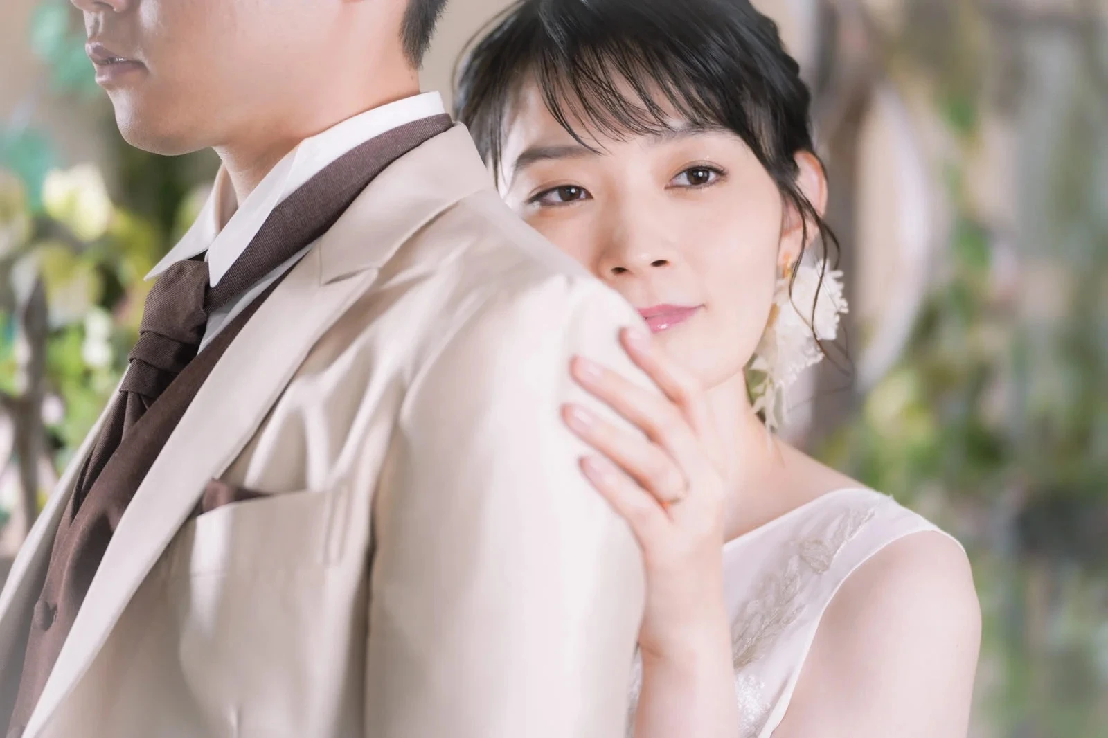 結婚式で彼の背中に顔を寄せる物憂げな女性