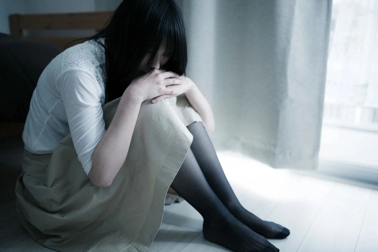 膝を抱えて過去に浸り込む女性