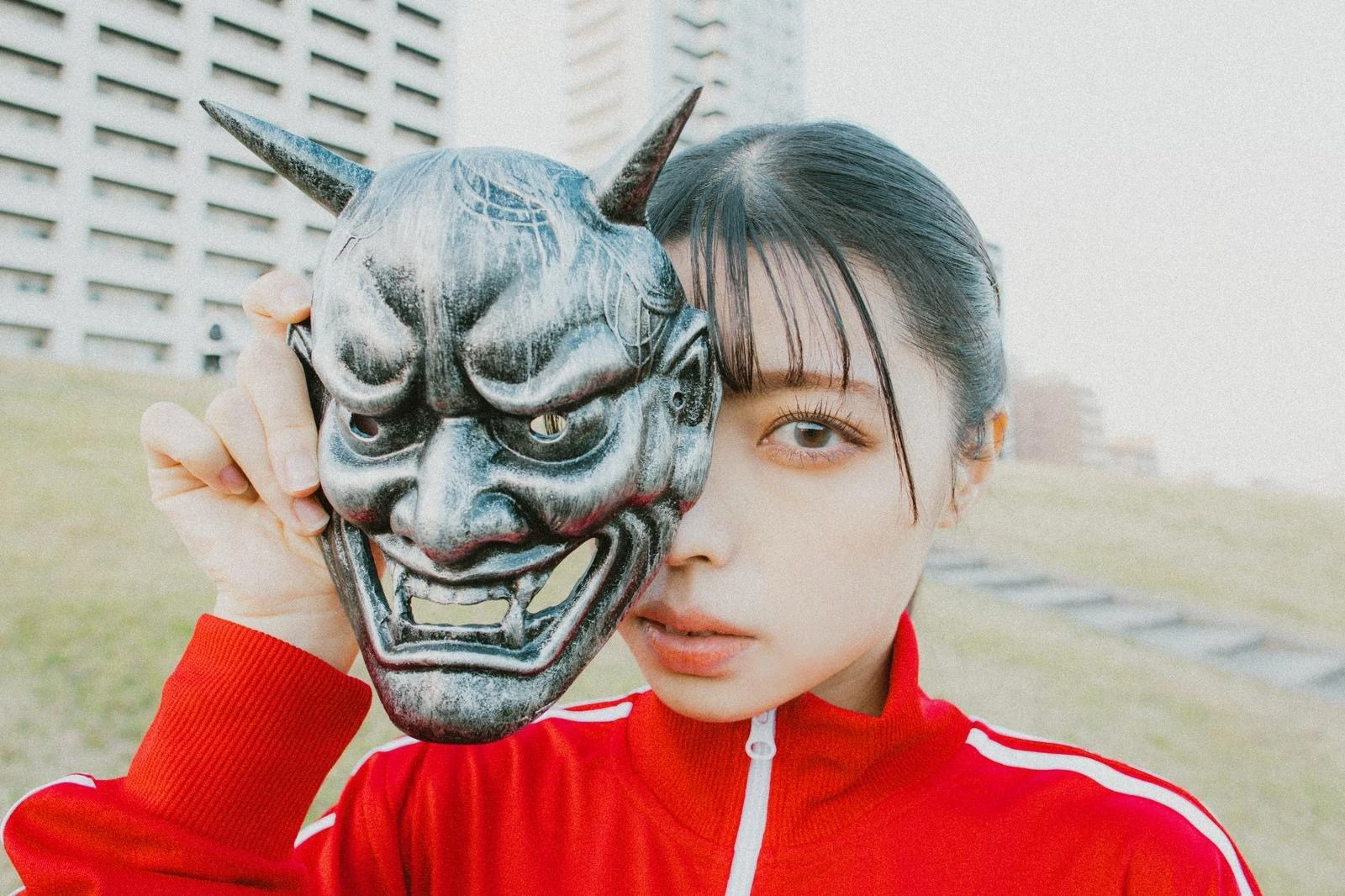 鬼の仮面を外す素顔の若い女性