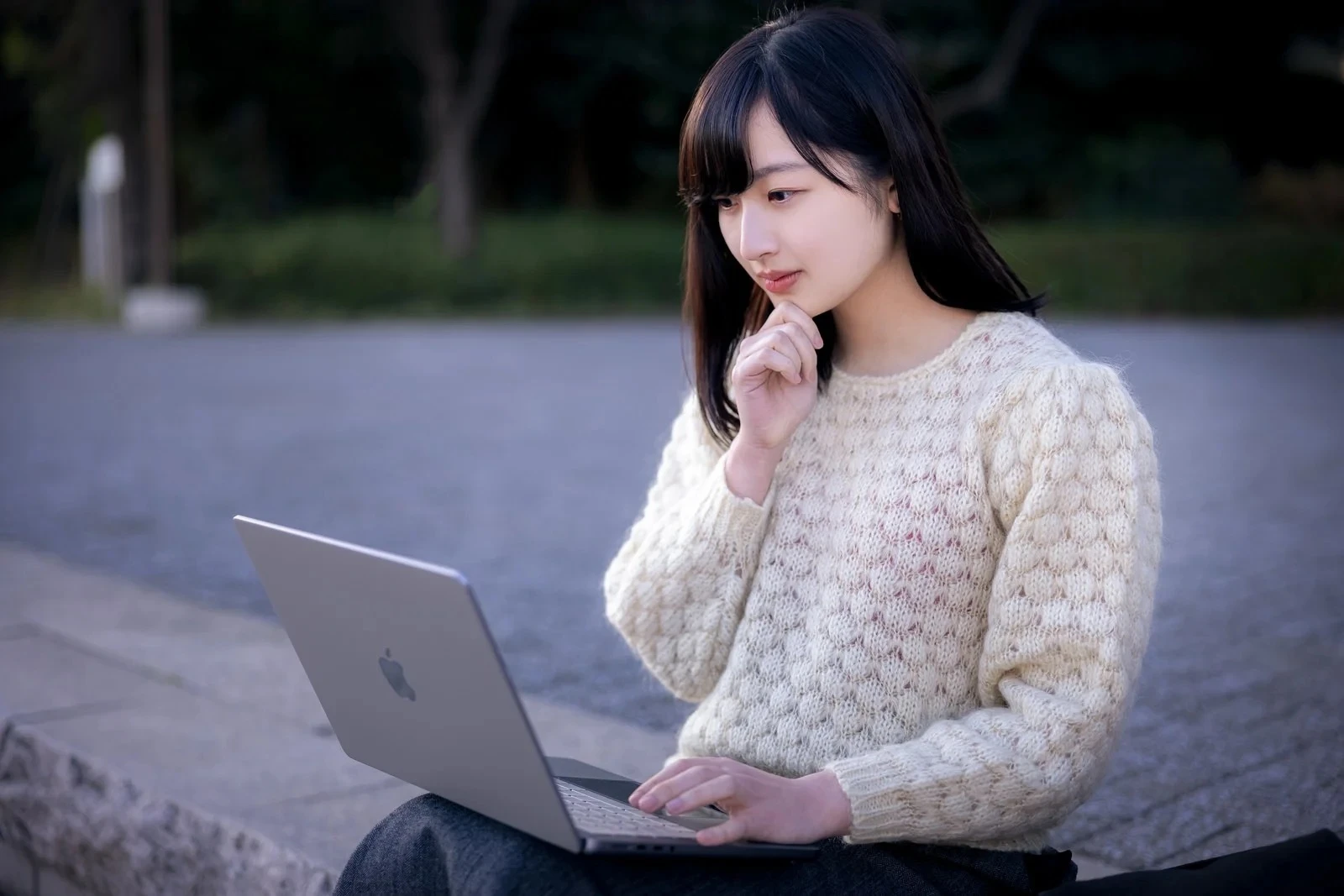 ノートPCを前に計算する若い女性