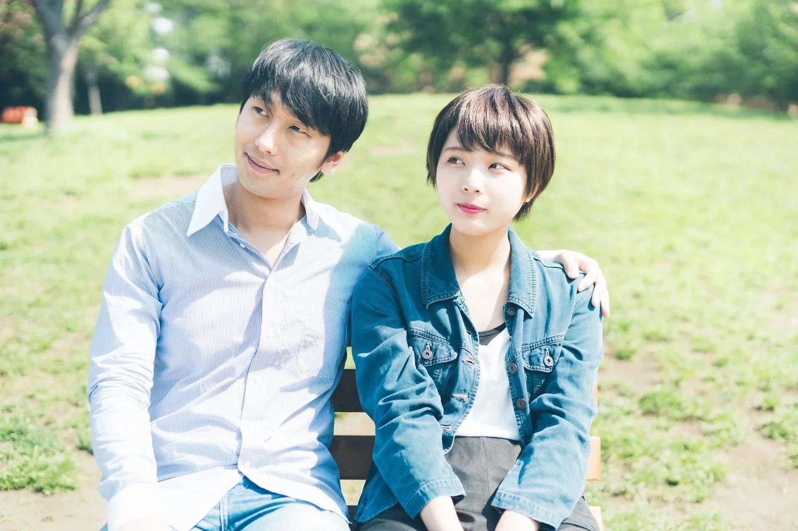 公園で肩を寄せ合うカップル