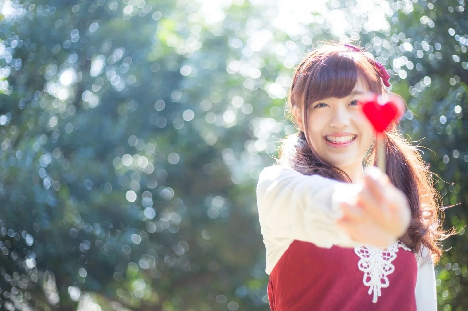 ハートマークのキャンディを手に持つ若い女性