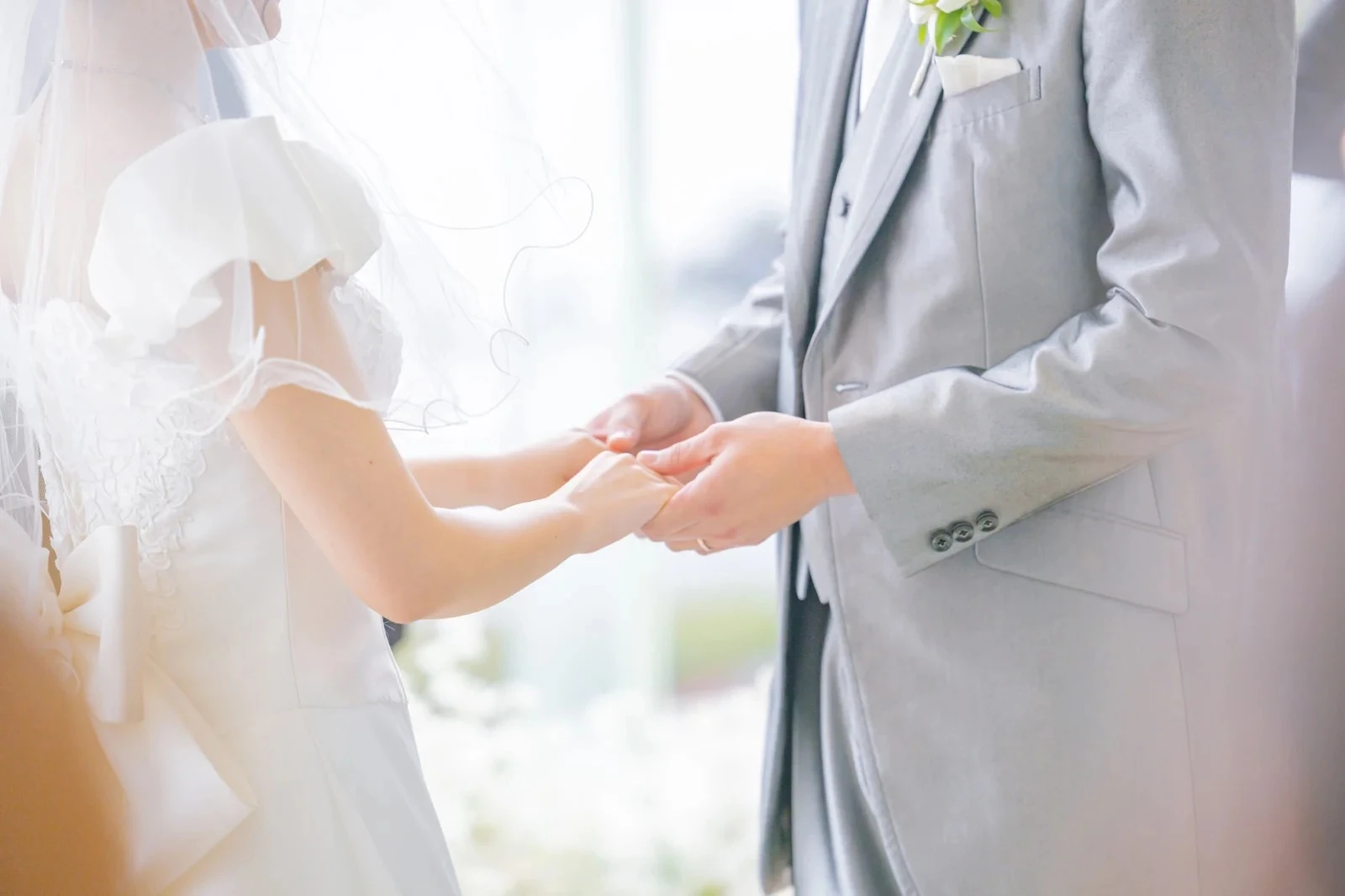 結婚式で優しく手を取りあうカップル