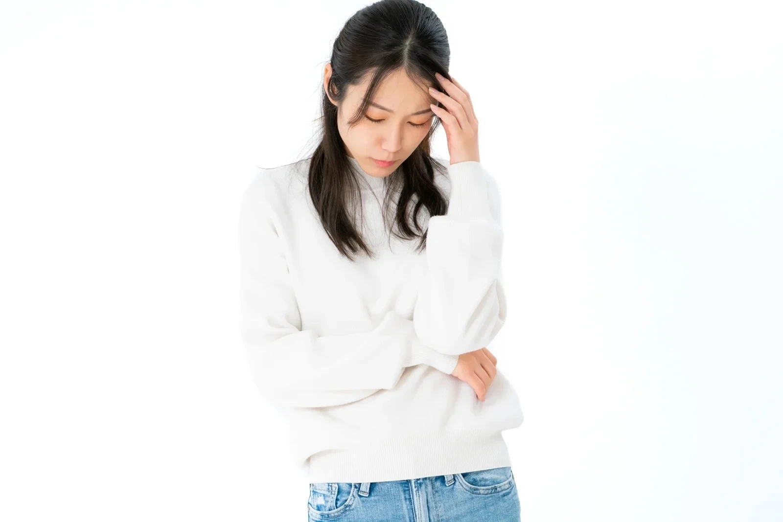 思い悩む白いセーターの若い婚活女性