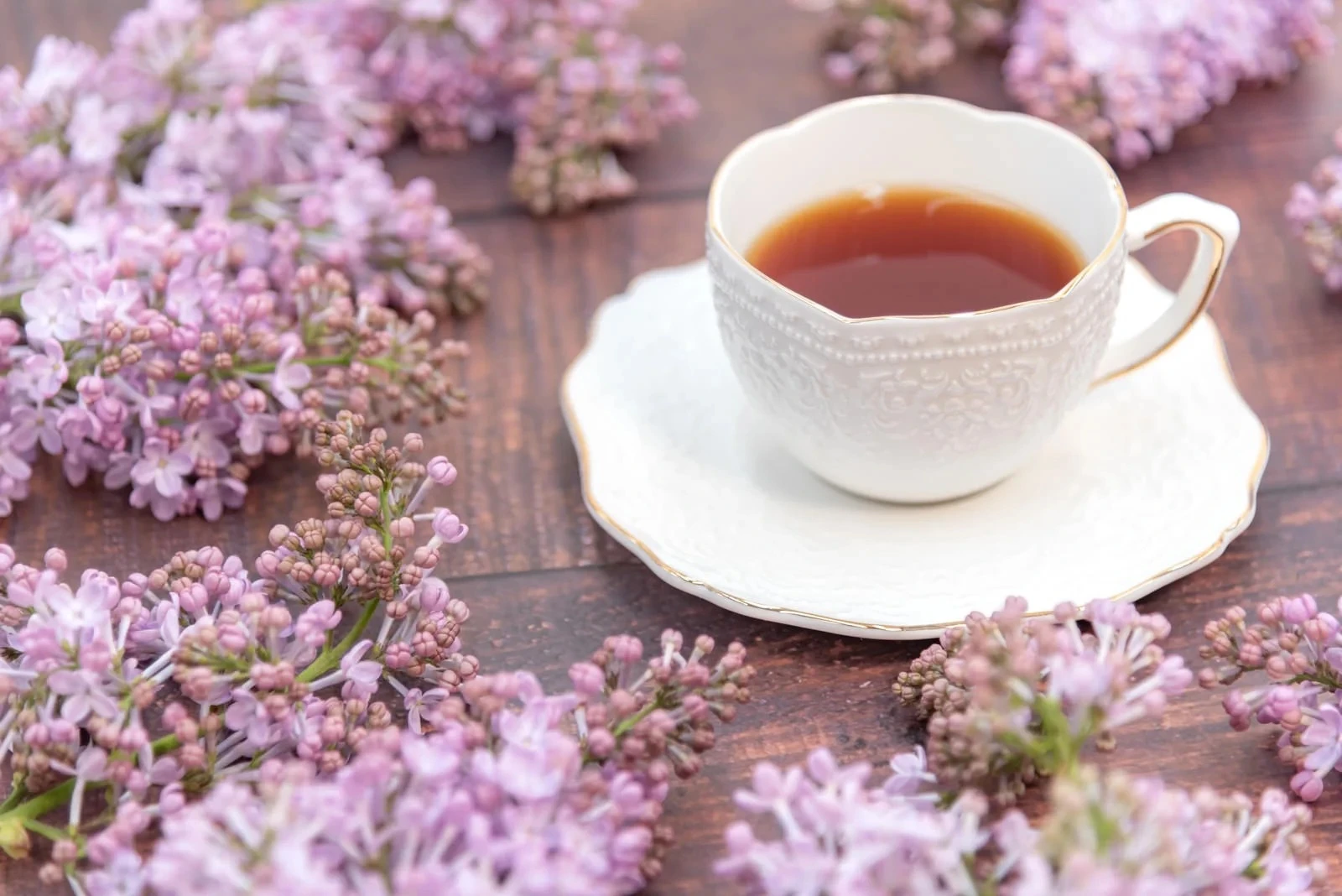 花で飾られたテーブルの上の紅茶カップ