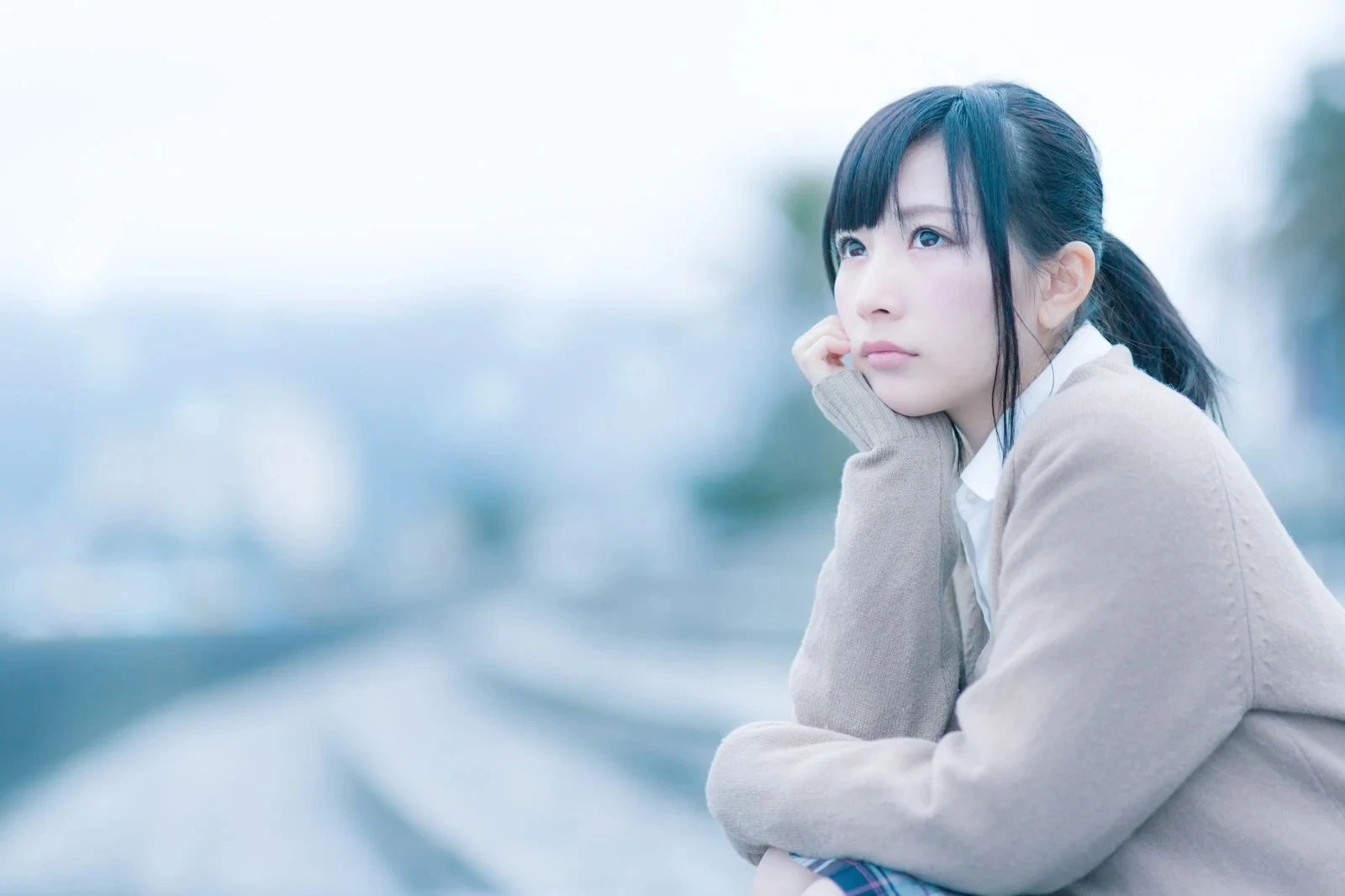 欄干に肘を付き遠くを見つめる女性