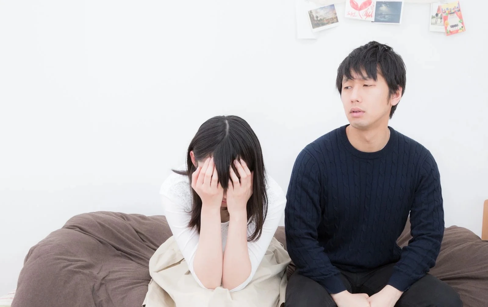顔を覆って泣く彼女と側で戸惑う彼氏