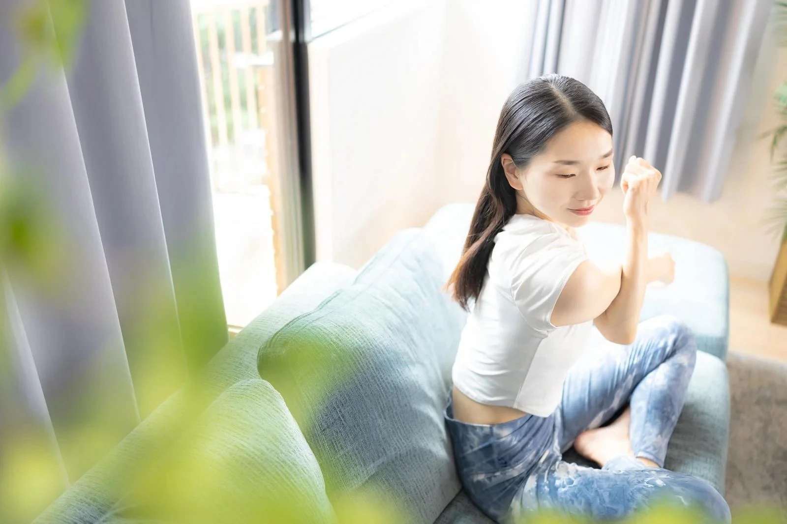 リビングでストレッチをする若い女性
