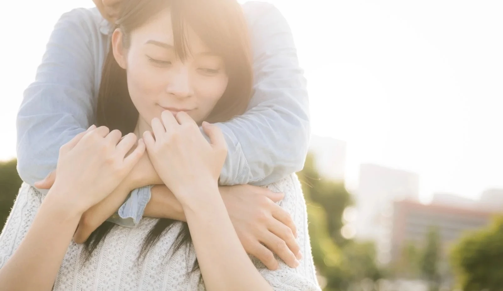 後ろからハグする彼と戸惑うその恋人