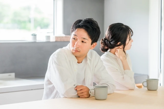 気まずく互いにそっぽを向くカップル